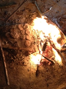 Bread being cook next to the fire.